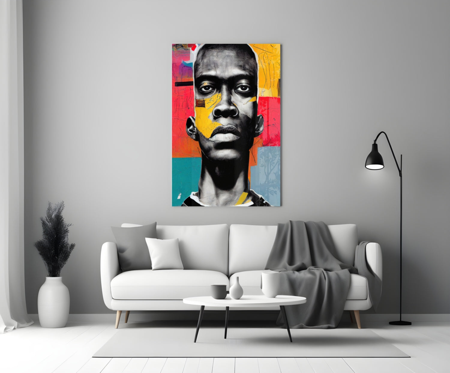 Colorful pop art portrait with black and white face featuring red, yellow, and teal geometric sections, displayed above a white sofa in a modern living room.