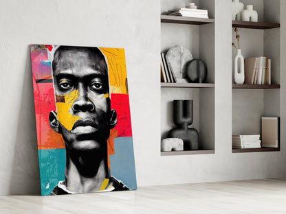 Colorful pop art portrait with black and white face on red, yellow, blue and teal background, leaning against white wall next to shelving.