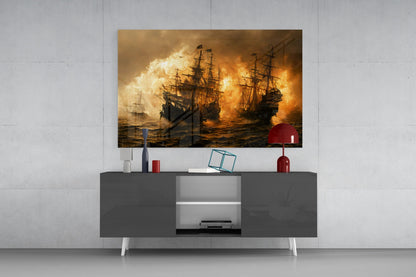 Framed glass wall art depicting naval ships in battle with flames displayed above dark gray media console with red lamp and decorative accessories.