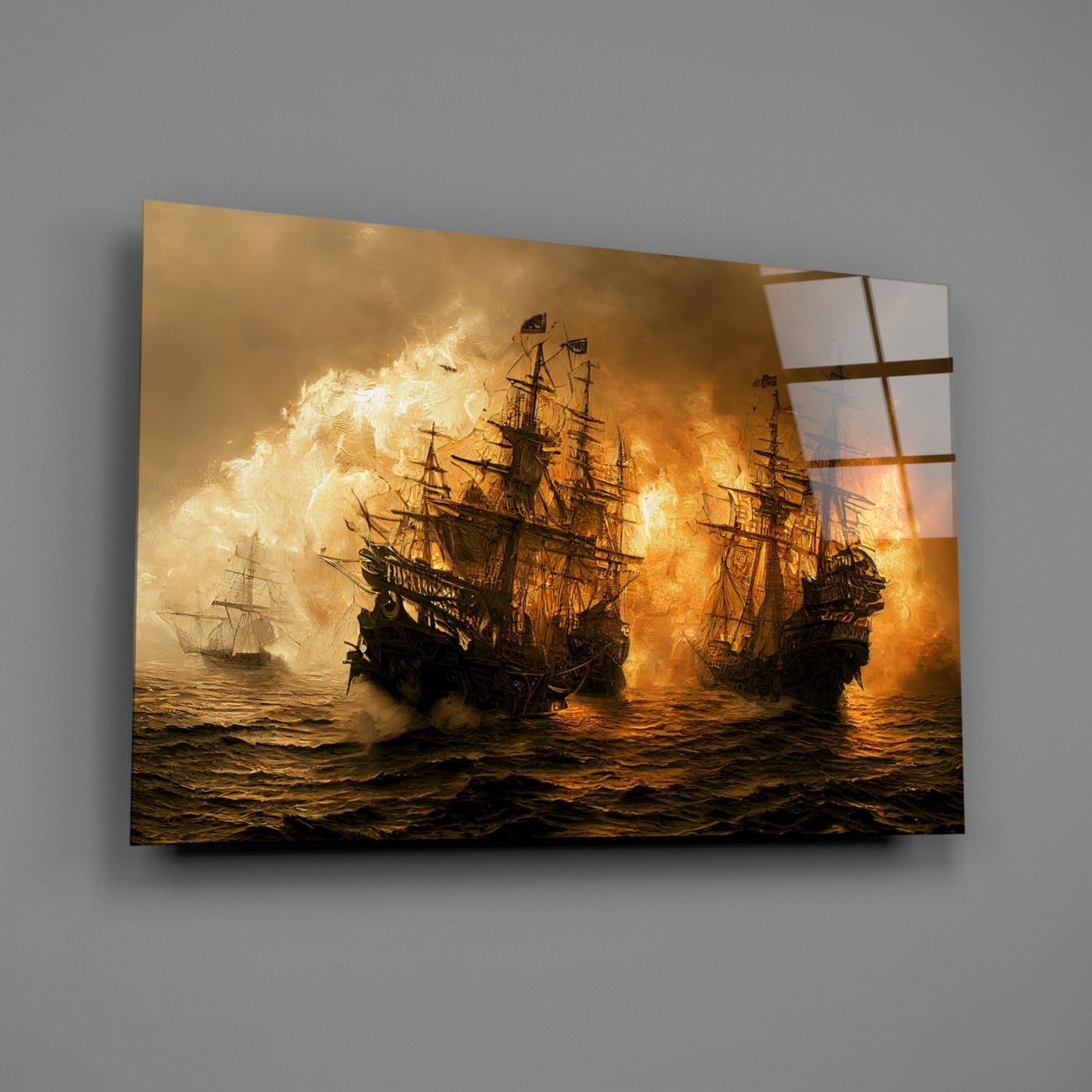 Glass wall art mounted on gray wall displays golden-lit naval battle scene with three tall ships engulfed in fire and explosions.