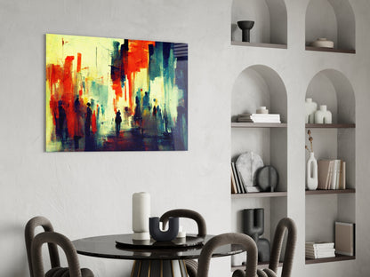 Vibrant abstract cityscape canvas with red, yellow, and blue tones hanging above a round black dining table with gray upholstered chairs.