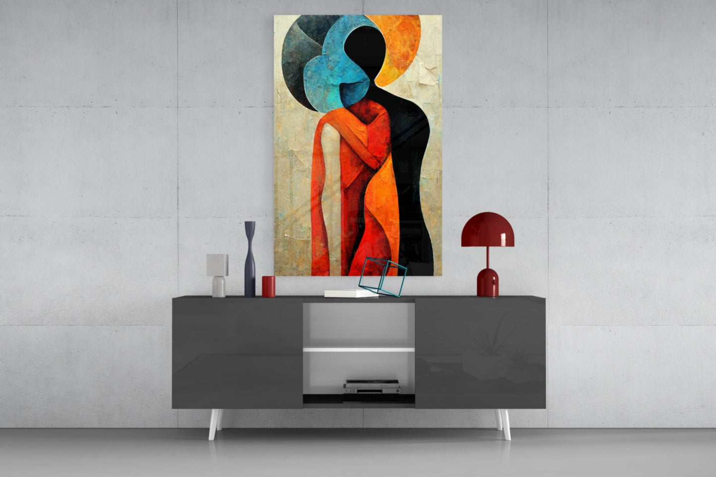 Abstract glass wall art featuring a stylized figure in red, orange, and blue tones displayed above a modern gray console table.