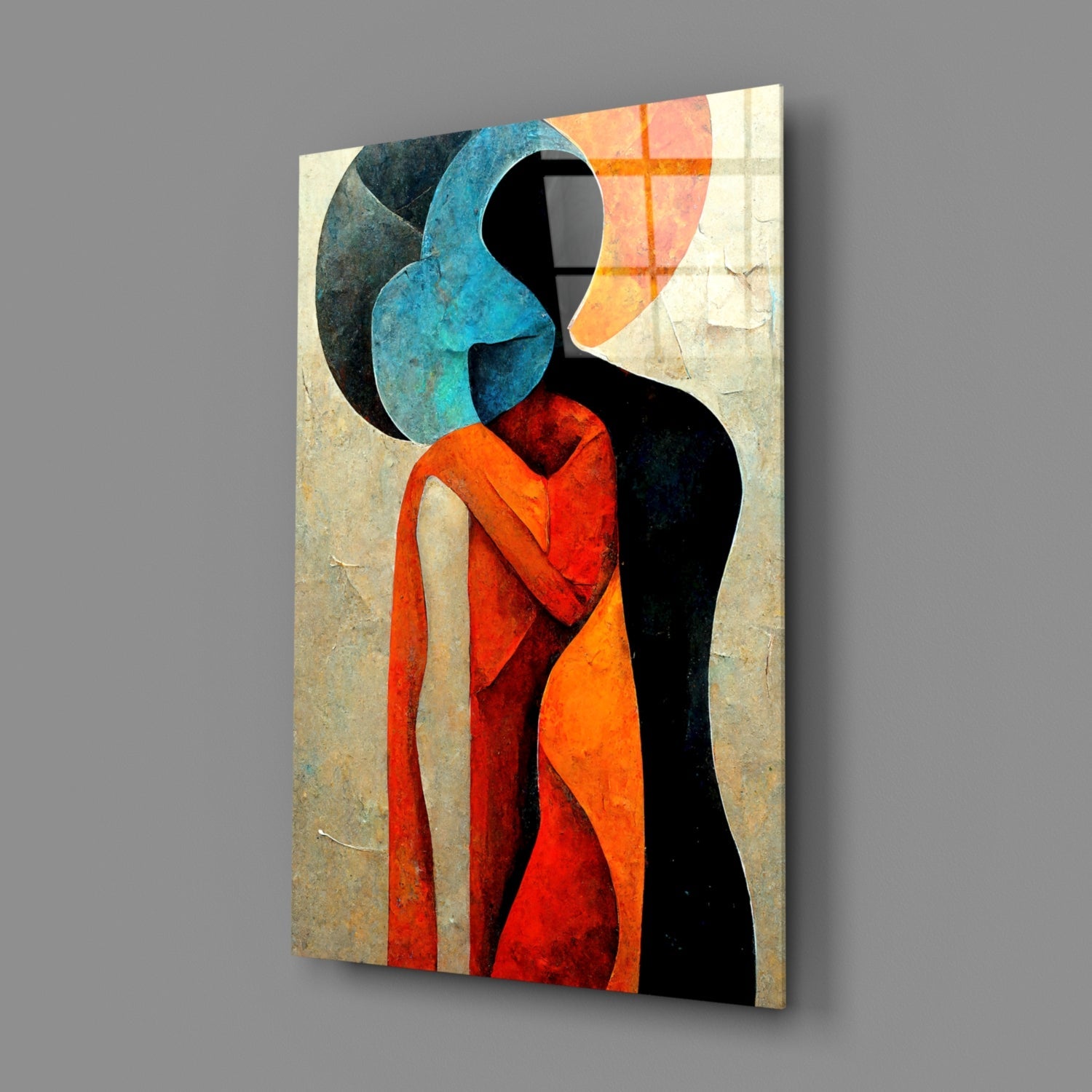 Abstract glass wall art depicting two faceless figures embracing, featuring blue, red, orange, and black colors on a textured beige background, shown at an angle.
