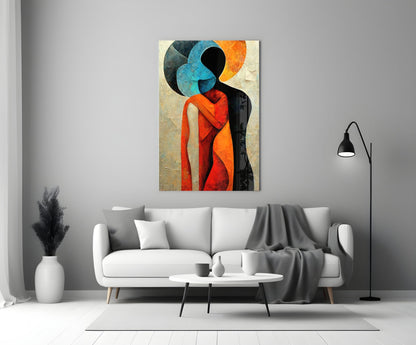 Abstract glass wall art depicting two stylized figures embracing in vibrant blue, orange, and red hues displayed above a white sofa in a modern living room.