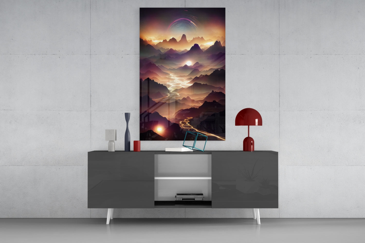 Framed glass wall art depicting layered mountains at sunset with glowing peaks and a purple celestial ring, displayed above a dark gray console table with white legs.