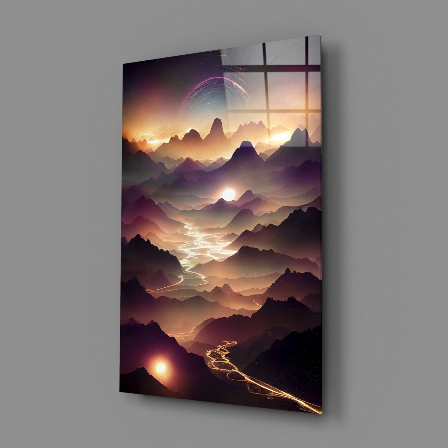 Angled view of glass wall art displaying layered mountains at sunset with glowing pink planetary ring and illuminated valley path, mounted on gray wall.