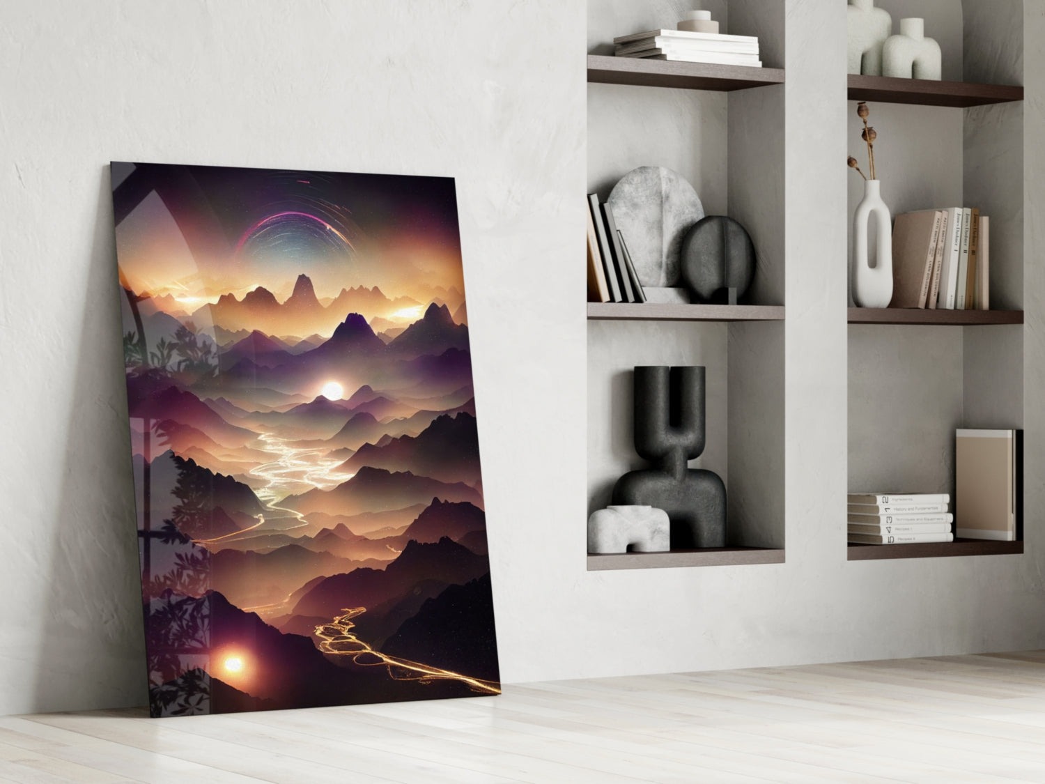 Glass wall art leaning against white wall displays golden sunset over layered mountains with glowing river, positioned beside white shelving unit with decorative items.