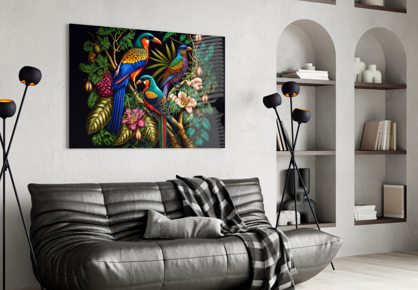 Colorful glass wall art featuring three parrots among flowers and foliage displayed above a black leather sofa in a modern living room.