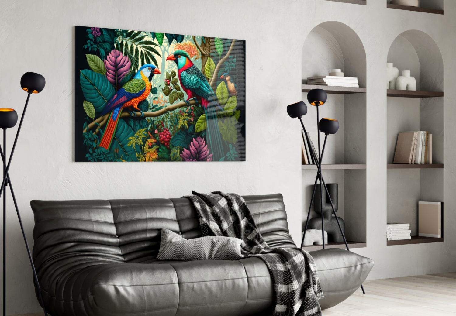 Vibrant glass wall art depicting two colorful parrots among tropical foliage and flowers displayed above a black leather sofa in a modern living room.