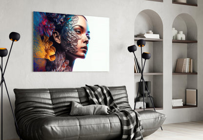 Colorful glass art depicting a woman's profile with abstract blue, red, and gold textures displayed above a black leather sofa in a modern living room.