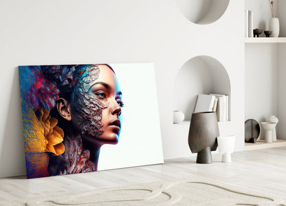Colorful glass art panel leaning against white wall displays profile of woman's face with vibrant blue, orange, and red paint effects.