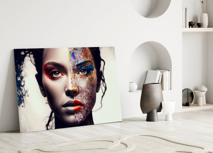 Colorful glass wall art featuring a split portrait with vibrant abstract patterns on one side, displayed leaning against white interior shelving.