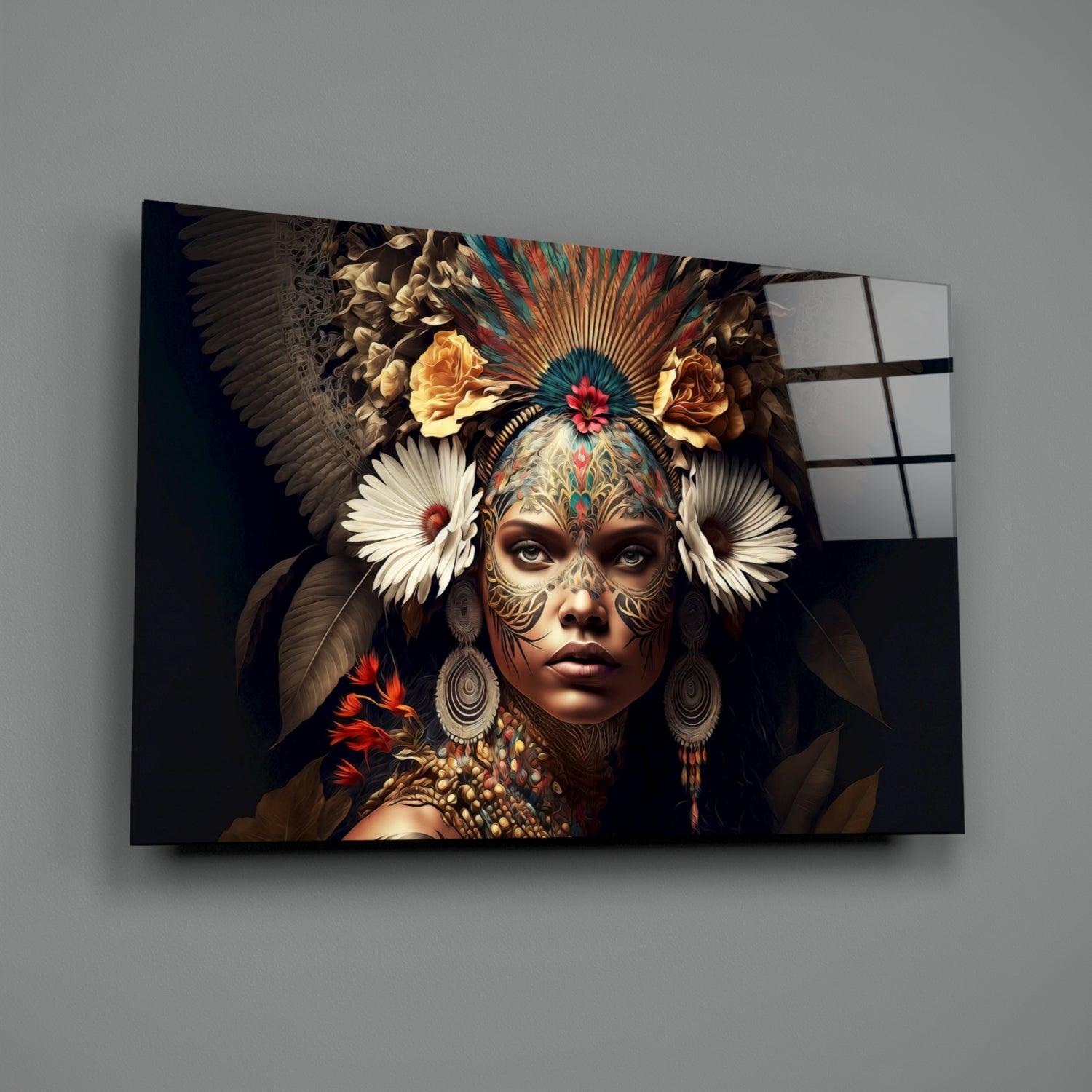 Glass wall art mounted on gray wall showing ornate portrait of woman with facial tattoos, feathered headdress, and floral elements in gold, red, and teal tones.