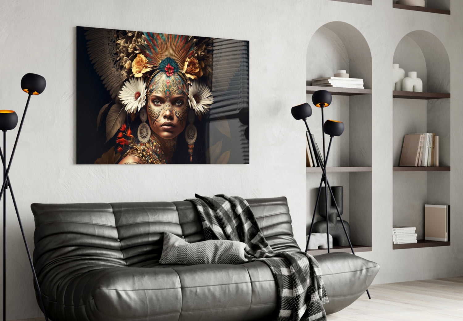Glass wall art depicting an ornately decorated woman with feathered headdress and golden facial markings displayed above a gray leather sofa in a modern living room interior.