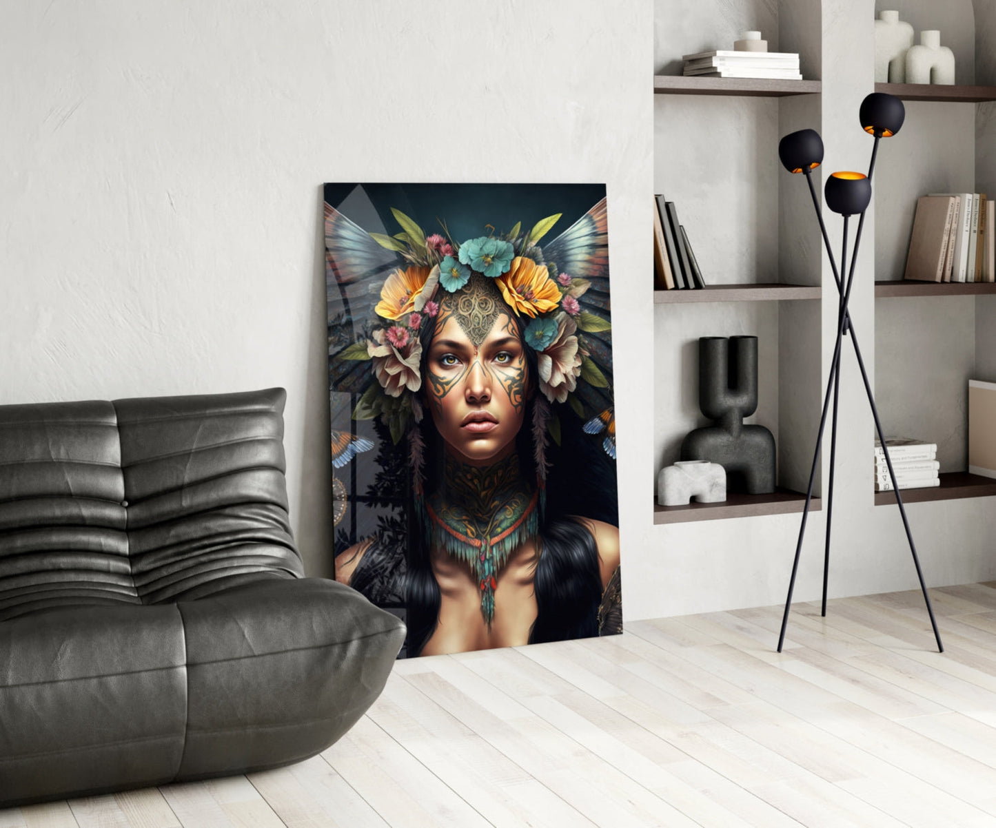 Modern living room with gray leather chair, glass wall art depicting woman with floral headdress and facial tattoos displayed centrally.