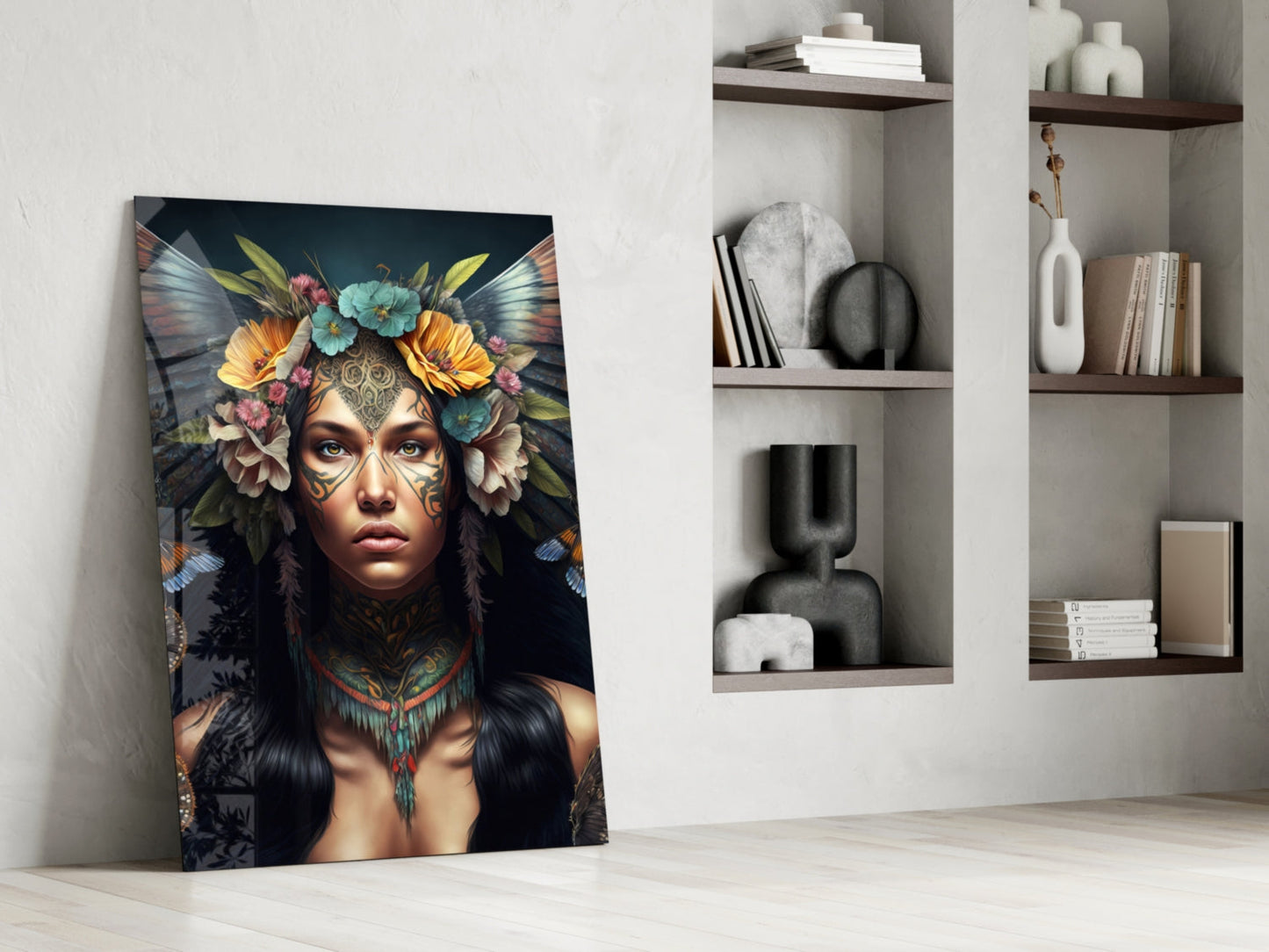 Leaning against white wall, glass art panel depicting woman with facial tattoos, colorful flowers, and iridescent wings against dark background, displayed beside built-in shelving.