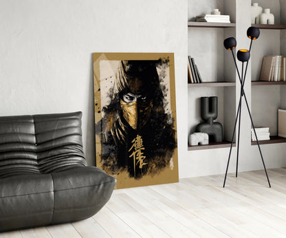 Gold and black glass wall art featuring a masked warrior with Asian characters, displayed in a modern living room with gray sofa and shelving.