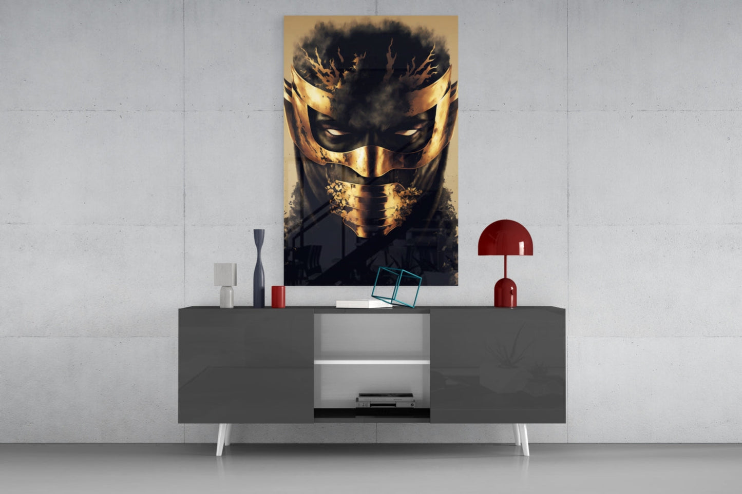 Gold and black masked face glass wall art displayed above gray media console with red lamp and decorative accessories.