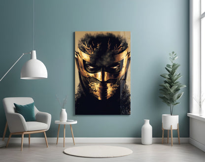 Gold and black masked face glass art displayed on teal wall above white chair and potted plant.