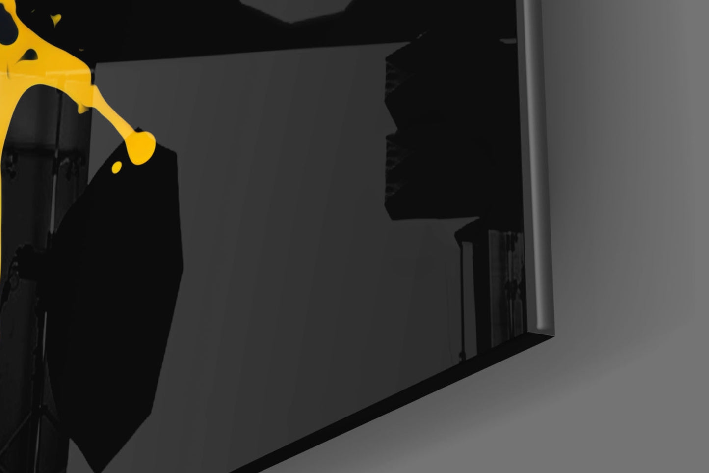Yellow and black abstract splash glass wall art displayed at an angle in a modern interior space.