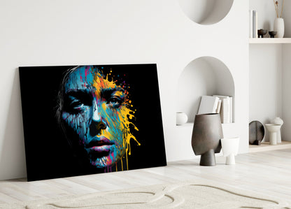 Colorful splash glass wall art leaning against white wall in minimalist room with decorative objects and shelving.