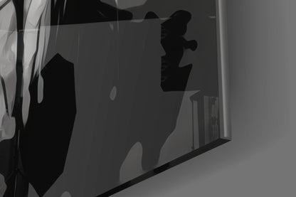 Silhouetted abstract scribbled design on frosted glass panel, photographed at angle showing depth and translucency against gray background.