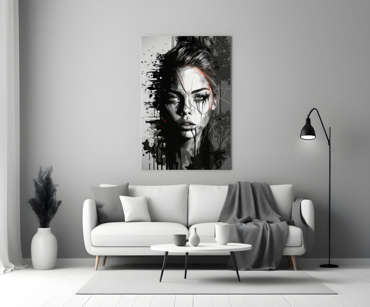 Black and white portrait glass wall art depicting a woman's face with splatter effects, displayed above a white sofa in a minimalist living room.