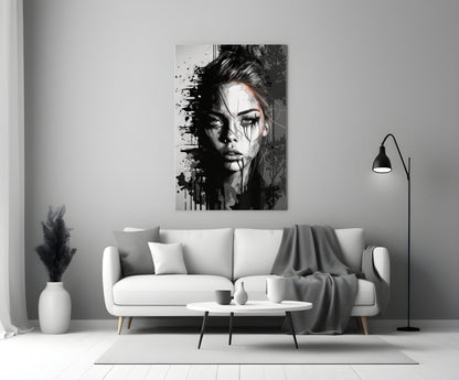 Black and white portrait glass wall art depicting a woman's face with splatter effects, displayed above a white sofa in a minimalist living room.