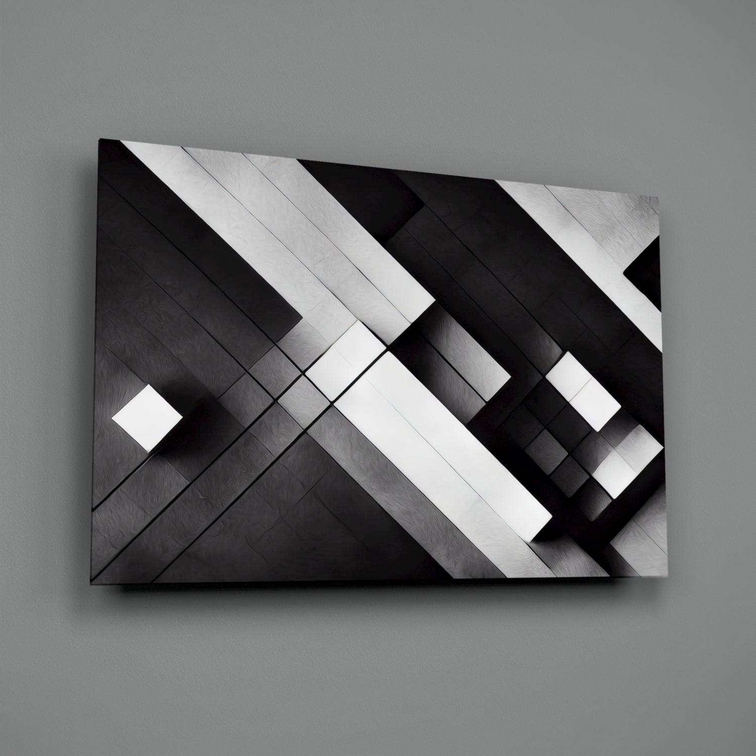 Black and white geometric glass wall art with diagonal intersecting planes and metallic brushed surface finish, displayed at an angle against gray background.
