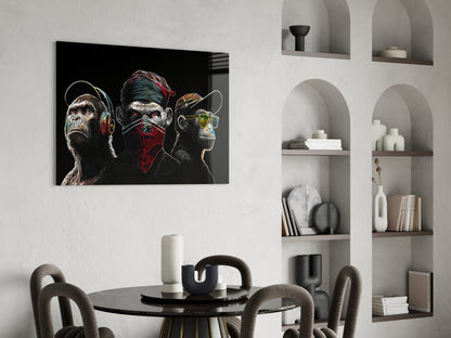 Neon-styled glass artwork of three stylized monkeys with headphones and bandana displayed above a dining table in a modern interior.