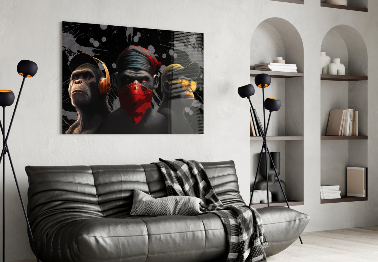Modern living room with black leather sofa displaying glass wall art of three stylized primates wearing headphones and bandana in orange, red, and yellow tones.