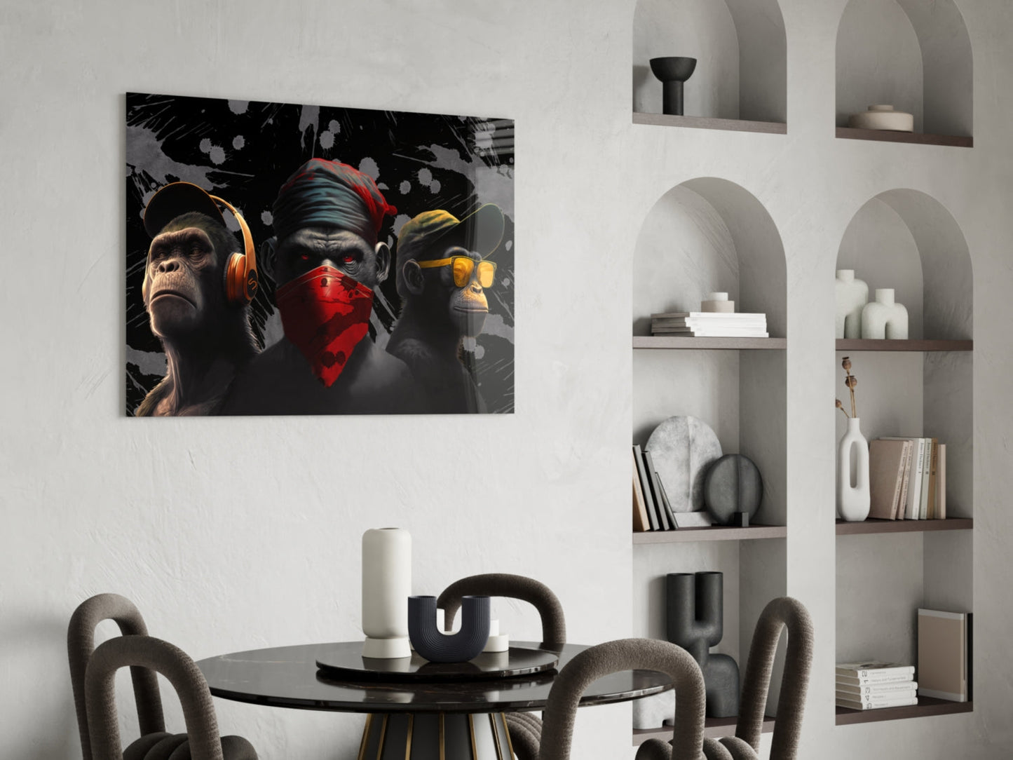 Three stylized monkeys wearing headphones and bandanas in black, red, and gold tones displayed above a dining table in a modern interior.