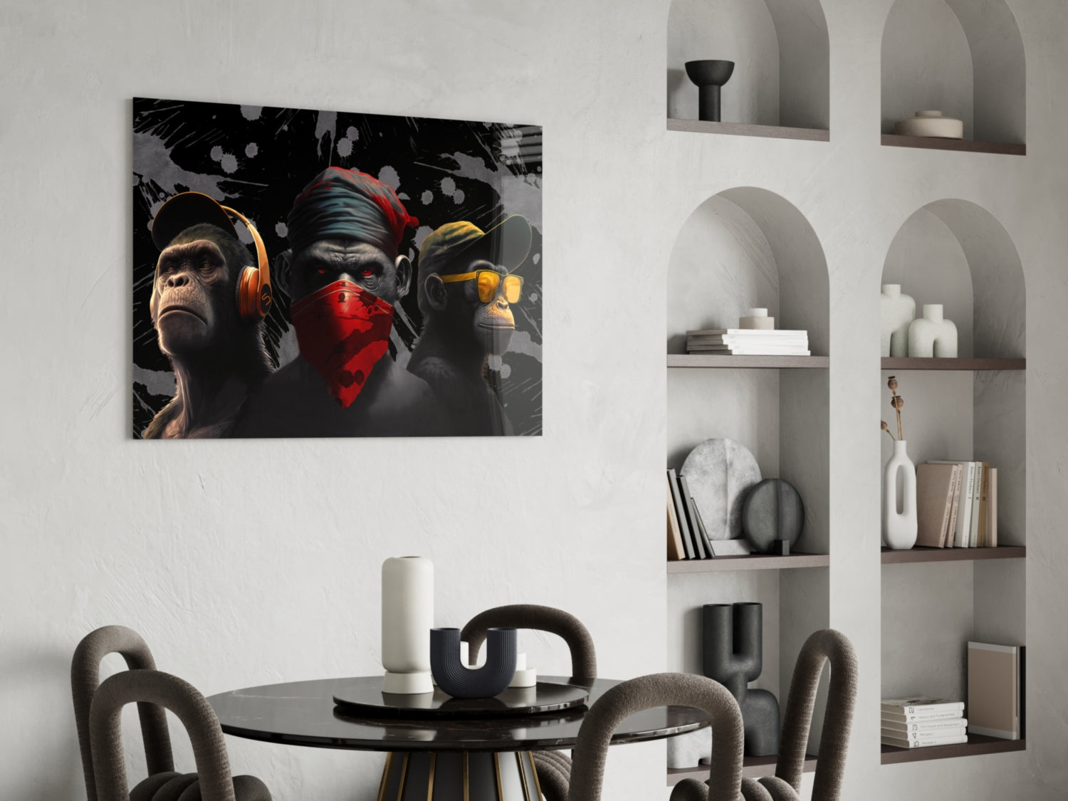 Three stylized monkeys wearing headphones and bandanas in black, red, and gold tones displayed above a dining table in a modern interior.