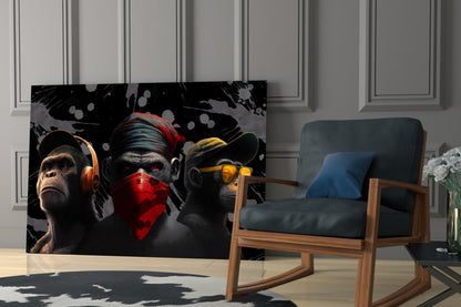 Three stylized monkeys wearing orange headphones, red bandana, and yellow sunglasses displayed on black glass panel in modern living room setting.