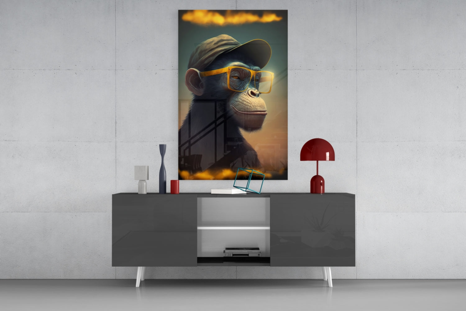 Glass wall art depicting a stylized chimpanzee wearing yellow-framed glasses and a baseball cap, displayed above a modern gray console table.
