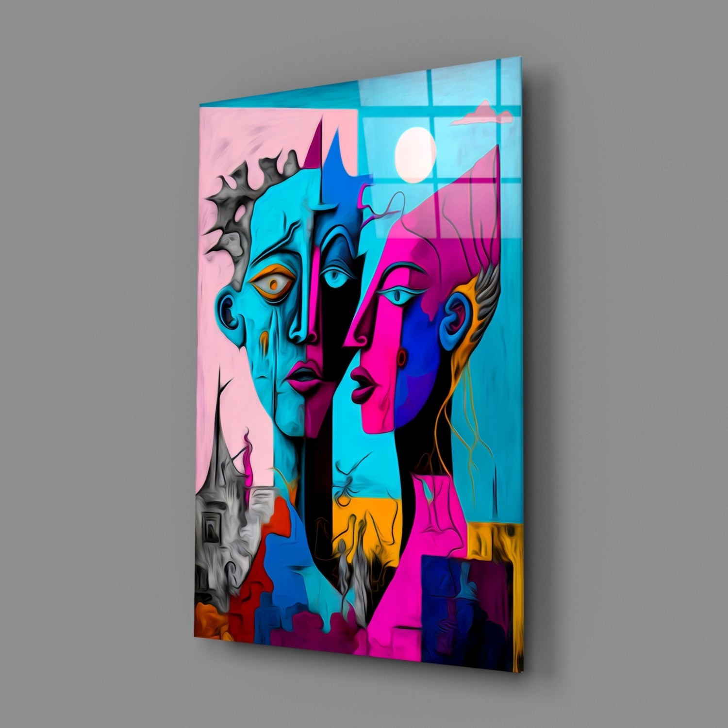 Angled perspective of colorful glass wall art featuring fragmented faces in cyan, magenta, and blue tones against pink background with window grid overlay.