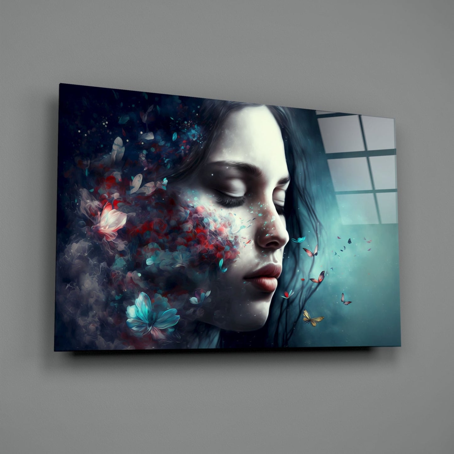 Glass wall art panel mounted on gray wall showing woman's profile with closed eyes, surrounded by red and turquoise butterflies and particles dissolving leftward.