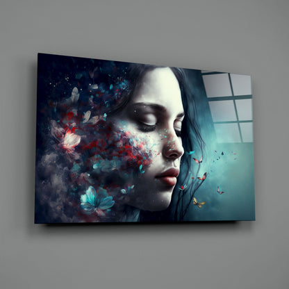 Glass wall art panel mounted on gray wall showing woman's profile with closed eyes, surrounded by red and turquoise butterflies and particles dissolving leftward.