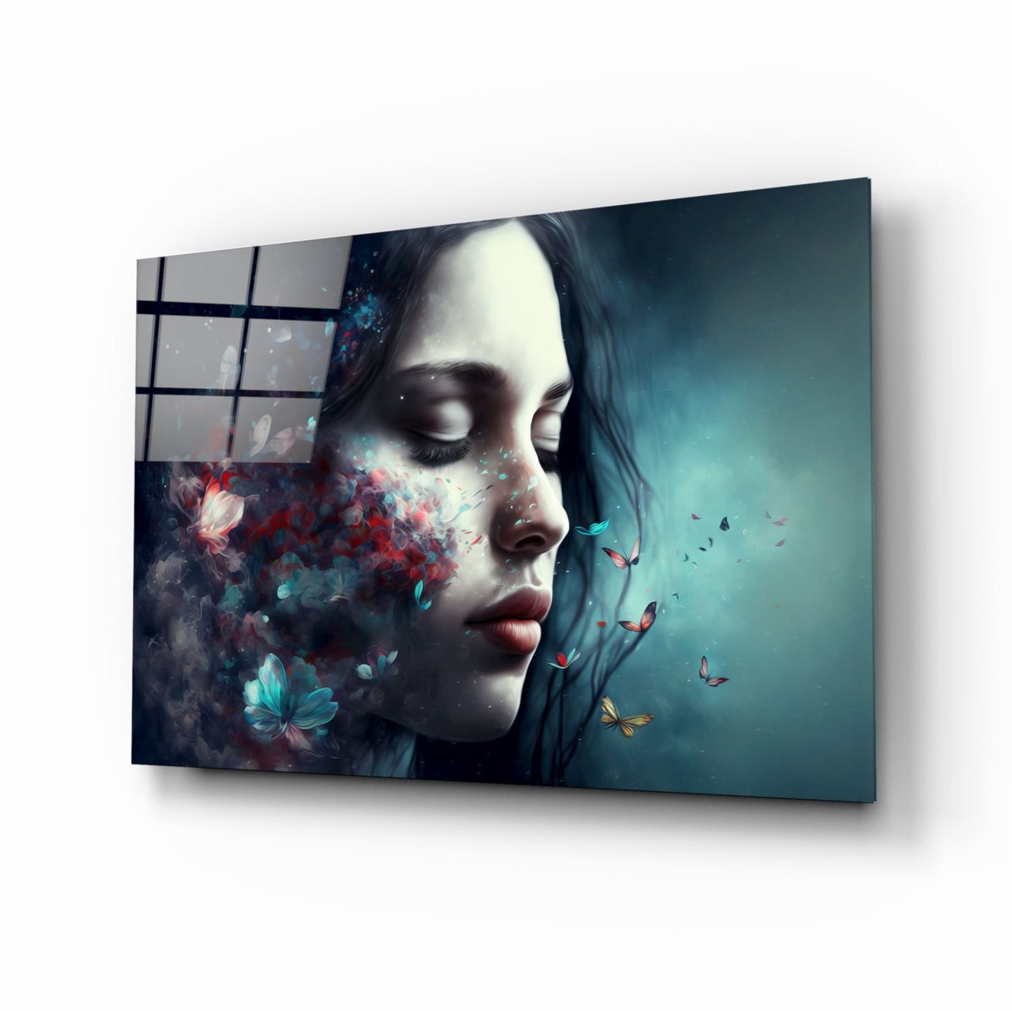 Angled perspective of glass wall art displaying a woman's profile with butterflies and flowers dispersing from her face against a teal gradient background.