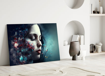 Glass wall art leaning against white wall displays woman's profile with blue and red butterfly dissolving effect on teal background.