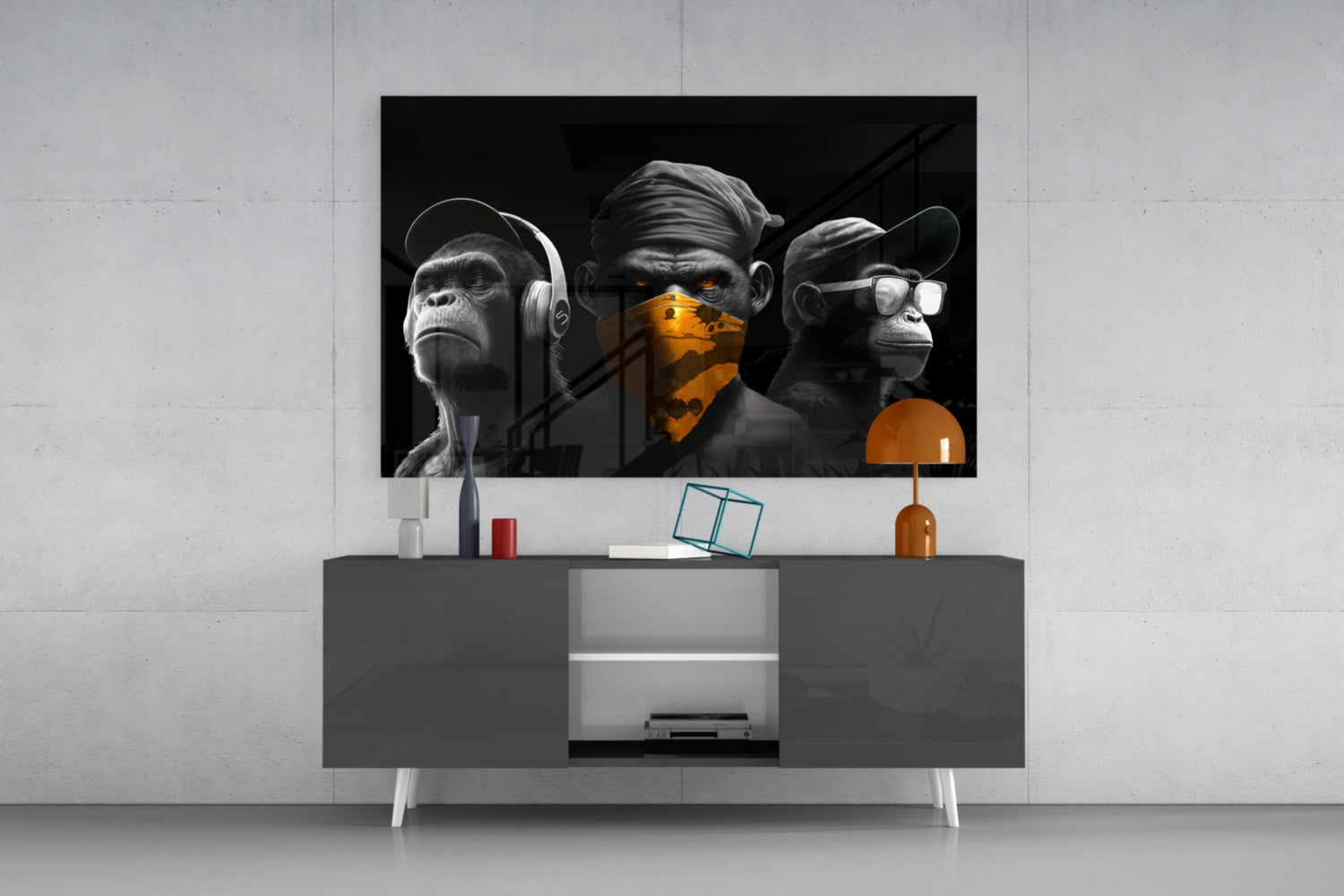Black and white monkeys with orange accents displayed on wall above modern gray media console with orange lamp and accessories.