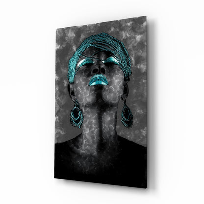 Portrait of a woman wearing a turquoise head wrap and matching beaded earrings against a textured gray background on glass wall art.