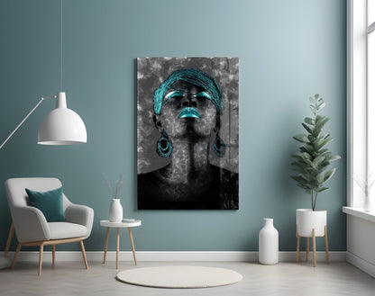 Modern room interior with turquoise and gray glass wall art portrait of woman wearing matching turquoise accessories displayed above white chair.