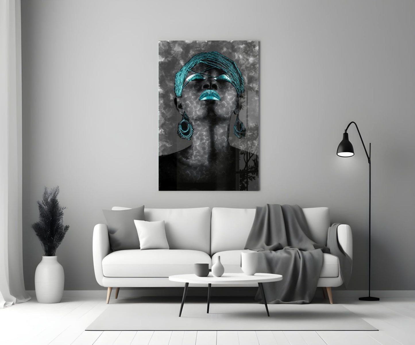 Black and white portrait with turquoise glowing eyes, lips, headwrap and earrings displayed above white sofa in modern living room.