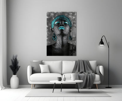 Black and white portrait with turquoise glowing eyes, lips, headwrap and earrings displayed above white sofa in modern living room.
