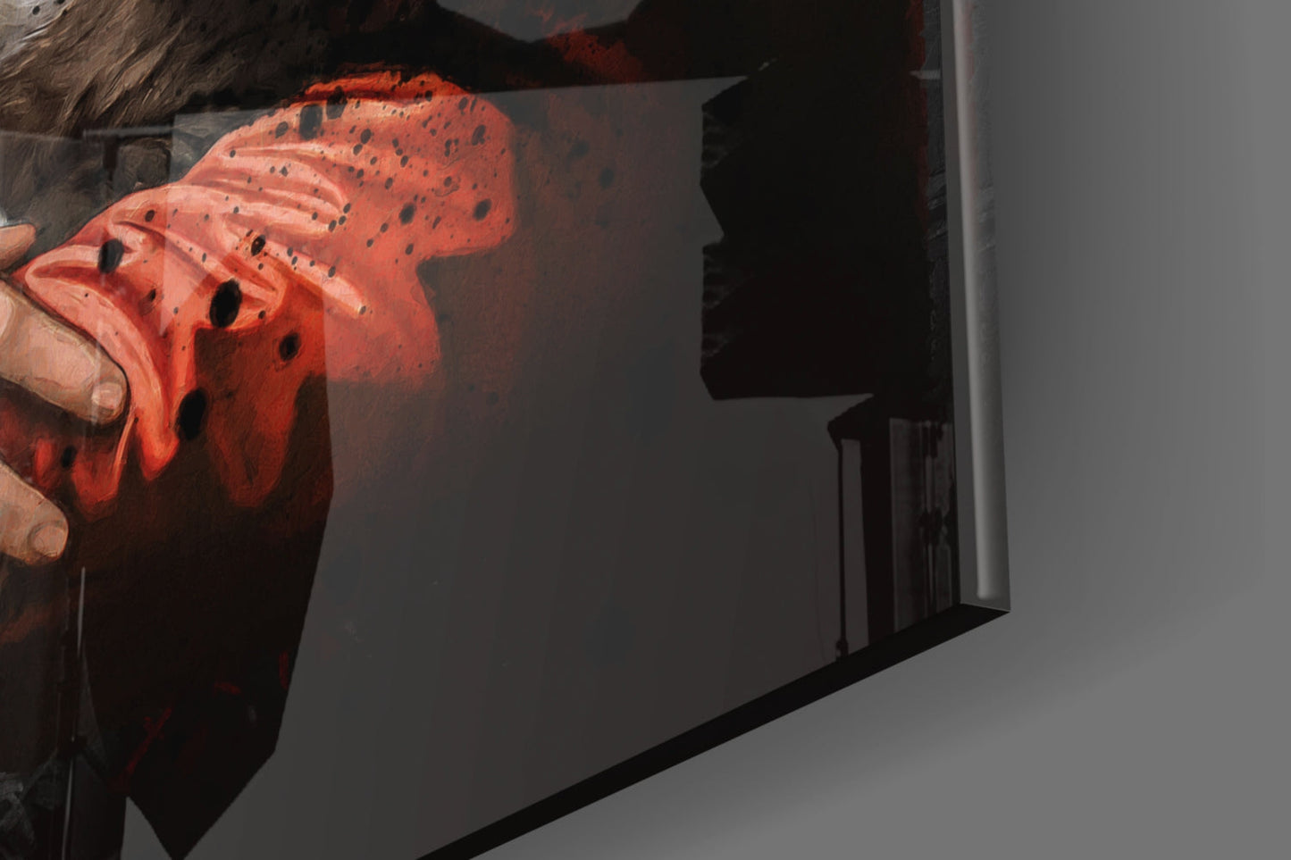 Close-up of red glass art piece with black speckled pattern held in hands, showing textured surface detail.