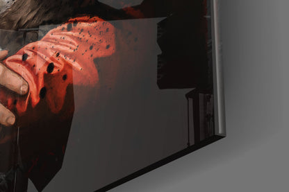 Close-up of red glass art piece with black speckled pattern held in hands, showing textured surface detail.