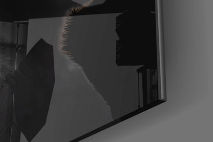 Backlit silhouette of three wise monkeys glass wall art mounted on white wall, showing profile shadows with warm rim lighting.
