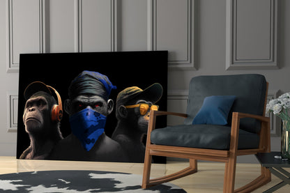 Three stylized monkeys with headphones, bandana, and sunglasses displayed on black glass panel in modern living room setting.