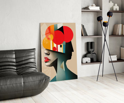 Modern living room interior featuring geometric abstract portrait artwork leaning against wall beside black leather chair and floor lamp.